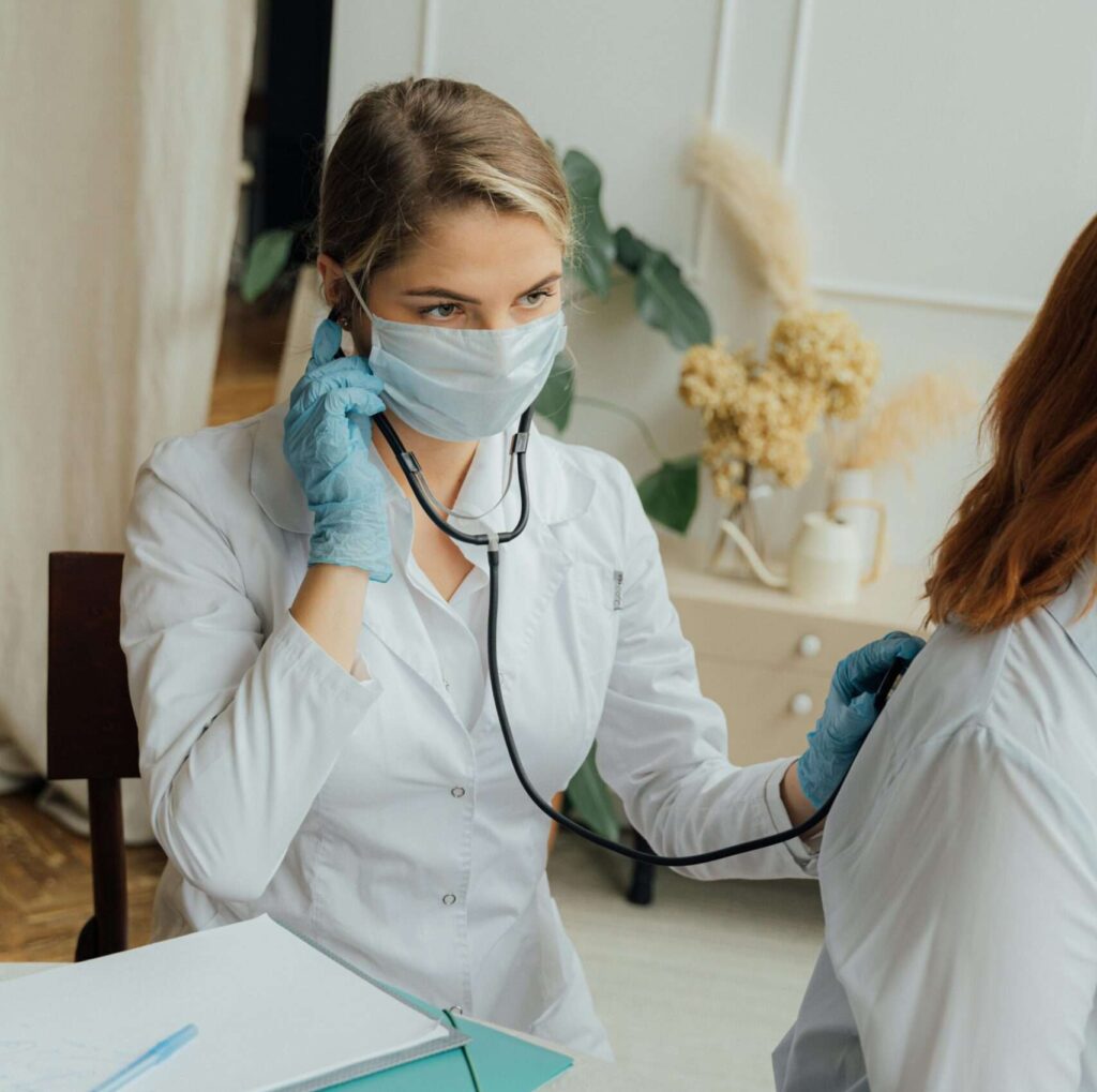 nurse checking patient with stethoscope