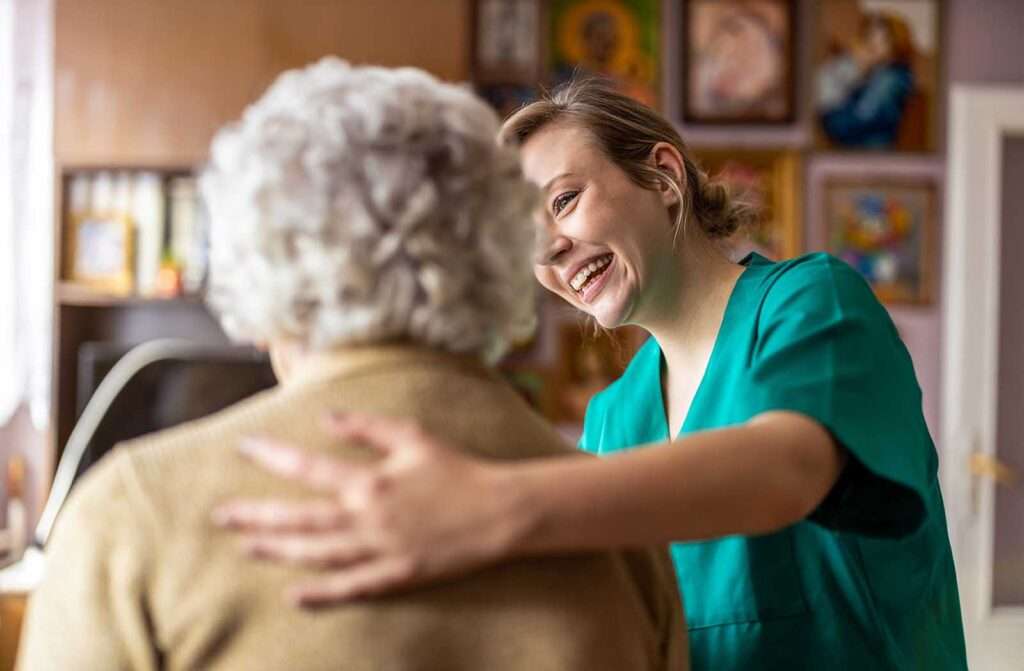 nurse with arm round old lady